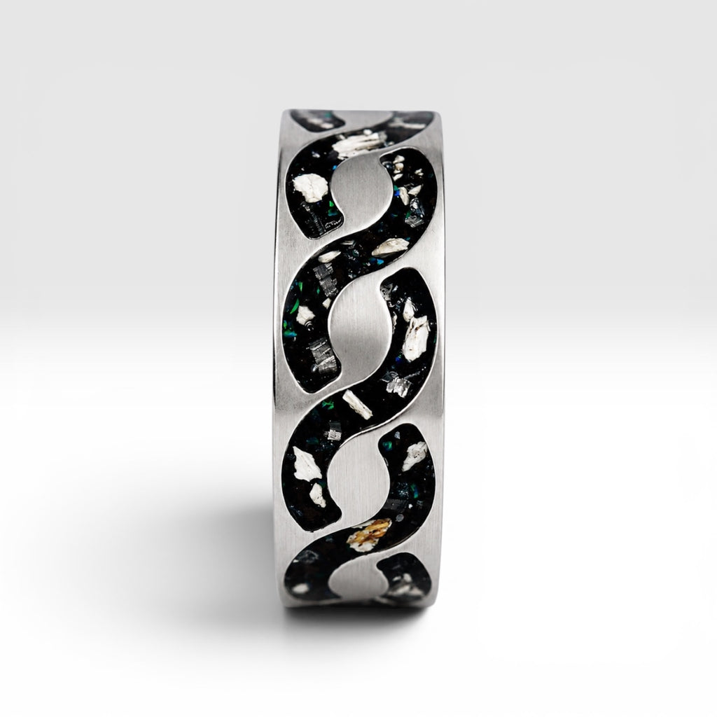 Abyssforge titanium ring featuring Megalodon tooth fragments, Campo del Cielo meteorite shavings, Mount Etna lava stone, green opal accents, and a sculpted flowing pattern.
