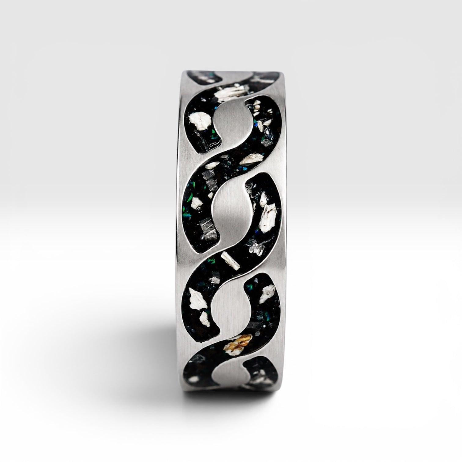 Abyssforge titanium ring featuring Megalodon tooth fragments, Campo del Cielo meteorite shavings, Mount Etna lava stone, green opal accents, and a sculpted flowing pattern.