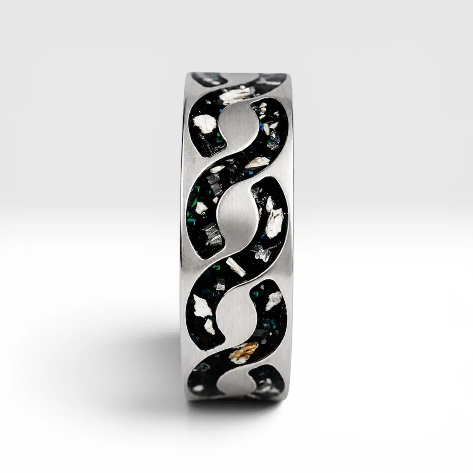 Abyssforge titanium ring featuring Megalodon tooth fragments, Campo del Cielo meteorite shavings, Mount Etna lava stone, green opal accents, and a sculpted flowing pattern.