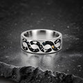 Abyssforge titanium ring featuring Megalodon tooth fragments, Campo del Cielo meteorite shavings, Mount Etna lava stone, green opal accents, and a sculpted flowing pattern.