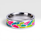 Arcadia titanium ring featuring a colorful abstract inlay with multi-color glow-in-the-dark elements inspired by retro arcade aesthetics.