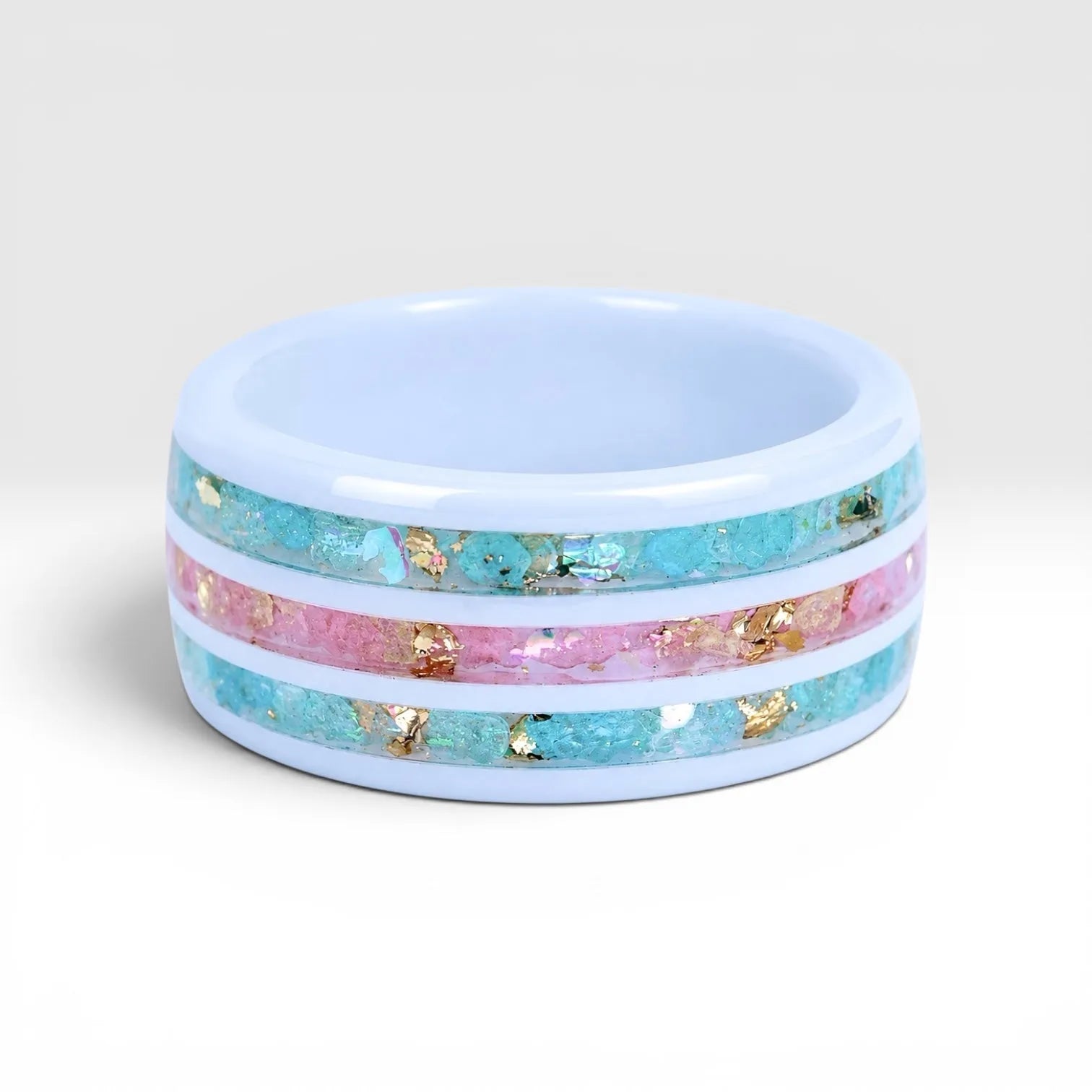 Bloomstripe white ceramic ring featuring three floral inlay channels with real flower petals, iridescent accents, and gold leaf details.