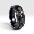 Cataclysm black titanium ring featuring meteorite fragments, blue dinosaur bone, lava stone inlay, and red glow accents with a rugged distressed finish.