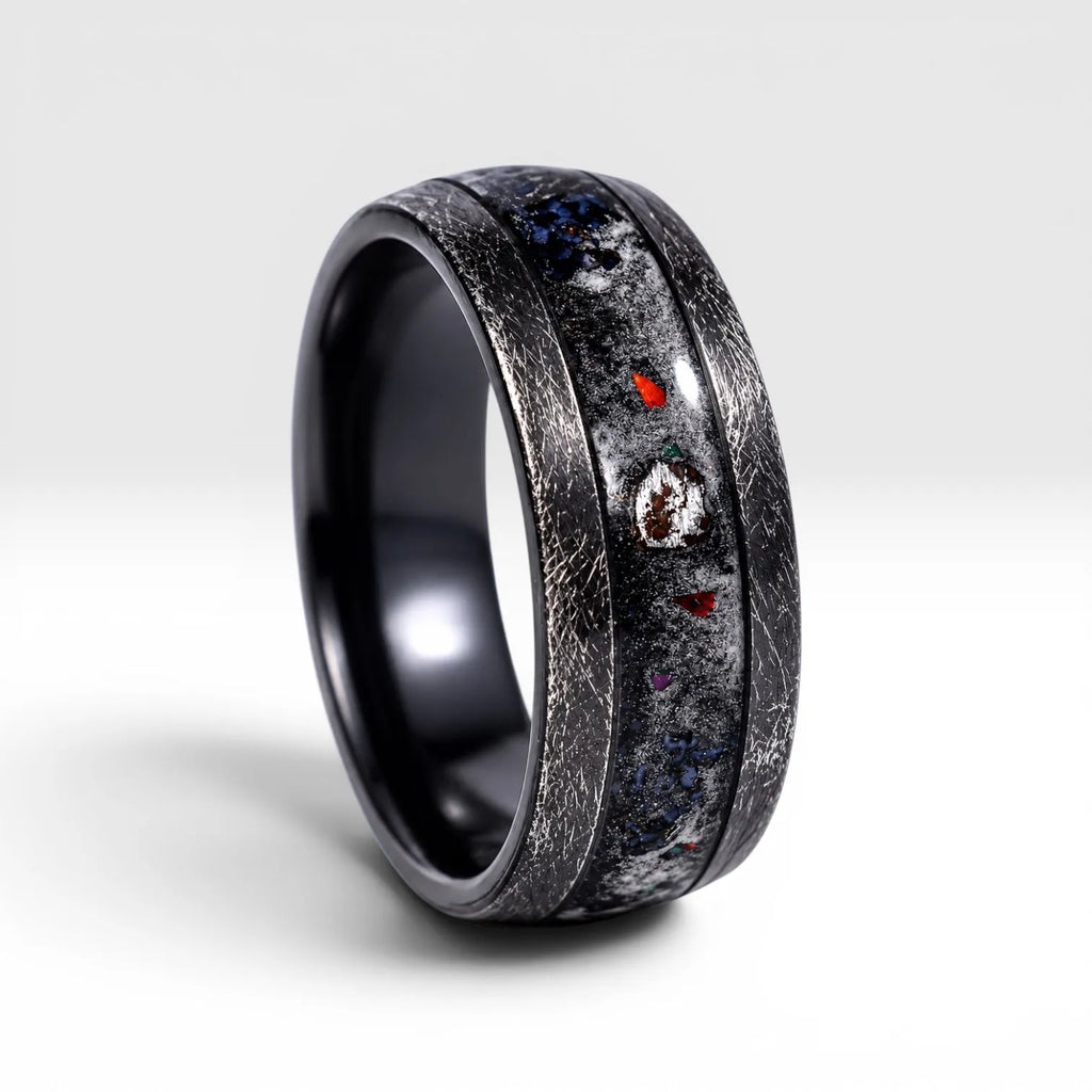 Cataclysm black titanium ring featuring meteorite fragments, blue dinosaur bone, lava stone inlay, and red glow accents with a rugged distressed finish.