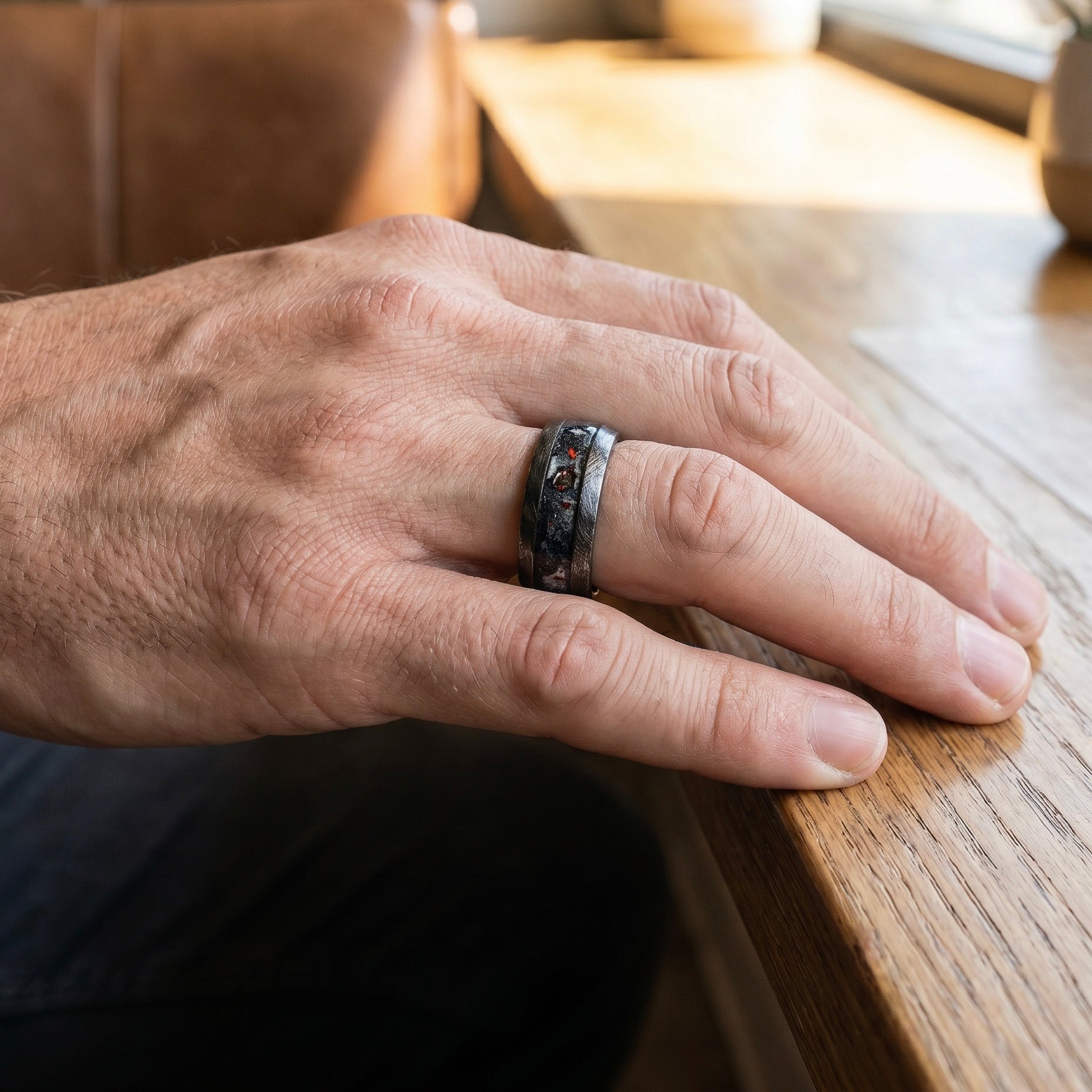 Cataclysm black titanium ring featuring meteorite fragments, blue dinosaur bone, lava stone inlay, and red glow accents with a rugged distressed finish.