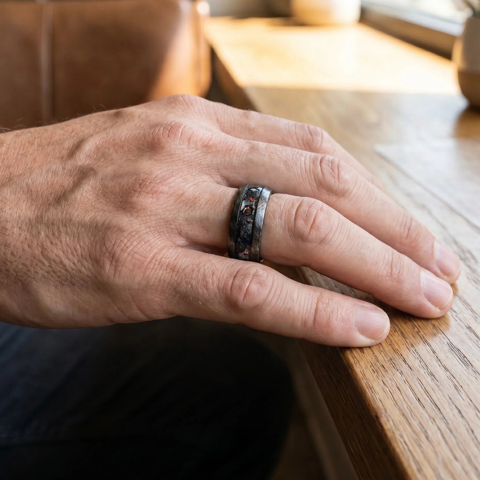 Cataclysm black titanium ring featuring meteorite fragments, blue dinosaur bone, lava stone inlay, and red glow accents with a rugged distressed finish.