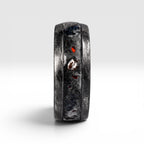 Cataclysm black titanium ring featuring meteorite fragments, blue dinosaur bone, lava stone inlay, and red glow accents with a rugged distressed finish.