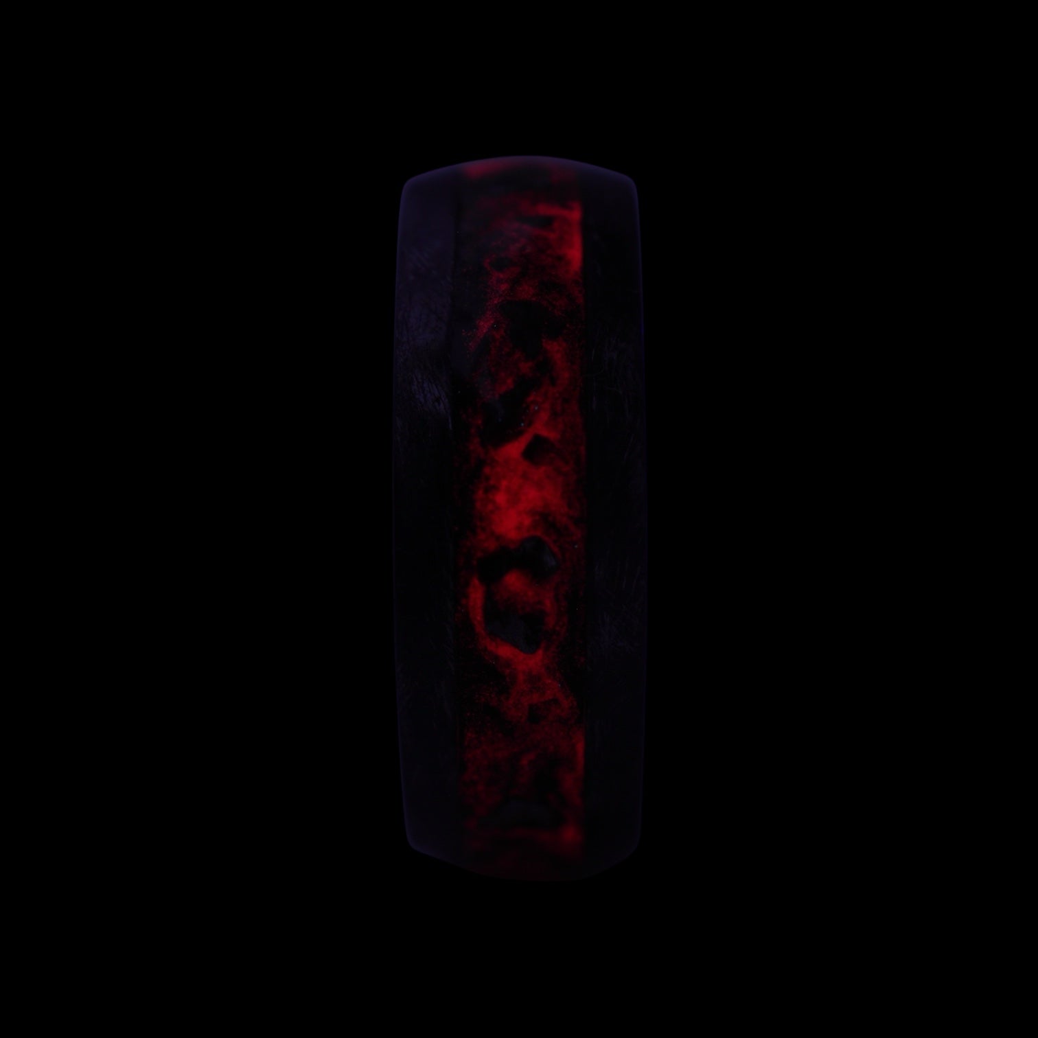 Cataclysm black titanium ring featuring meteorite fragments, blue dinosaur bone, lava stone inlay, and red glow accents with a rugged distressed finish.
