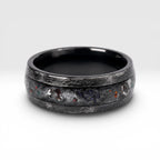 Cataclysm black titanium ring featuring meteorite fragments, blue dinosaur bone, lava stone inlay, and red glow accents with a rugged distressed finish.