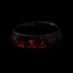 Cataclysm black titanium ring featuring meteorite fragments, blue dinosaur bone, lava stone inlay, and red glow accents with a rugged distressed finish.