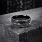Cataclysm black titanium ring featuring meteorite fragments, blue dinosaur bone, lava stone inlay, and red glow accents with a rugged distressed finish.