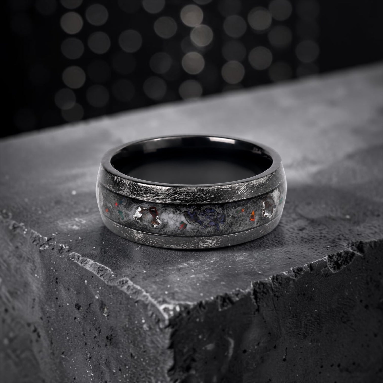 Cataclysm black titanium ring featuring meteorite fragments, blue dinosaur bone, lava stone inlay, and red glow accents with a rugged distressed finish.