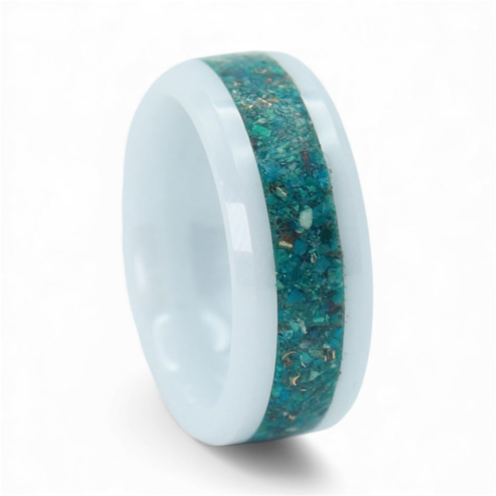 Close-up of white ceramic ring with crushed chrysocolla and brass accents showing soft blue and warm metallic contrast