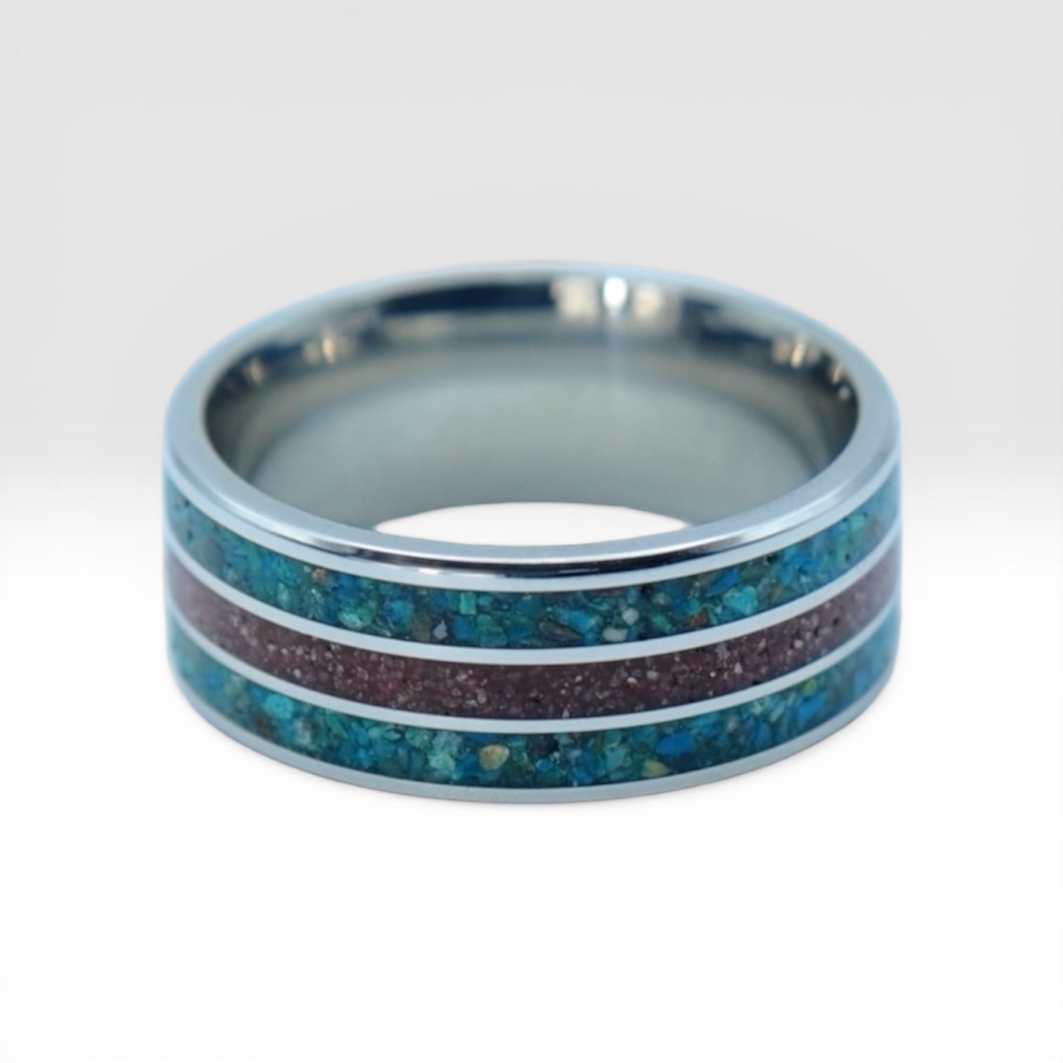 Tungsten ring with chrysocolla and cinnabar inlay featuring bold blue and red tones, polished band with textured design