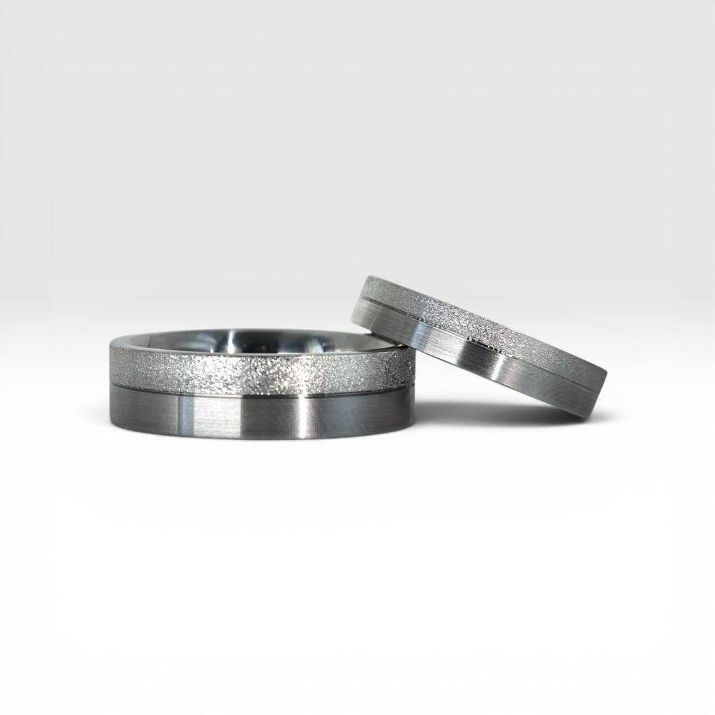 Matching two-tone wedding band set, 6mm his and 4mm hers, with frosted diamond burr top half and satin lower half separated by a precision groove, handcrafted in Utah