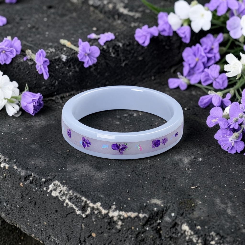 Forget Me Not white ceramic ring with real pressed flowers over a glow-in-the-dark background, handcrafted memorial jewelry