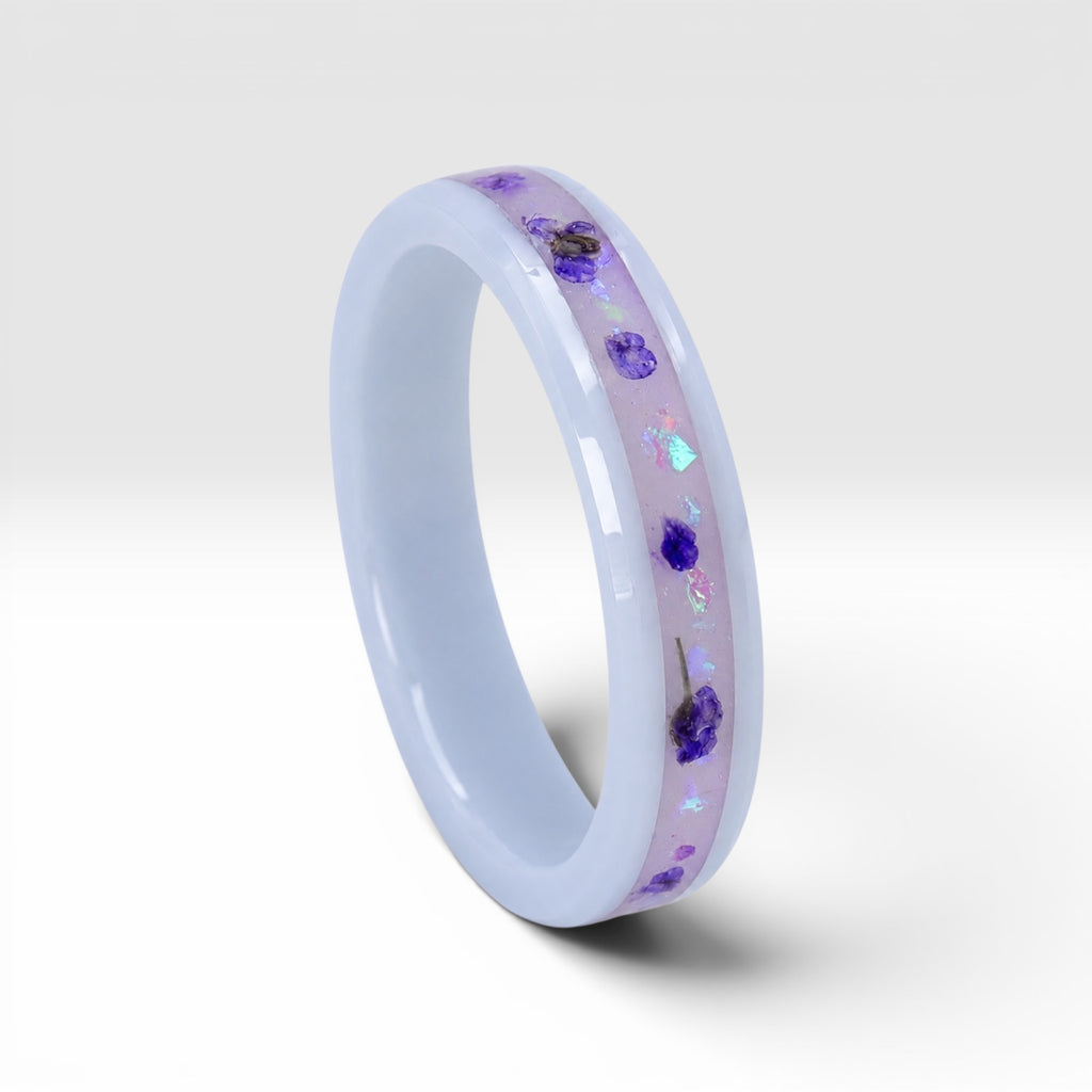 Forget Me Not white ceramic ring with real pressed flowers over a glow-in-the-dark background, handcrafted memorial jewelry