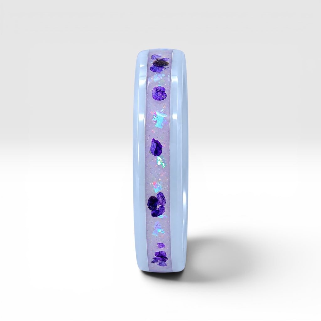 Forget Me Not white ceramic ring with real pressed flowers over a glow-in-the-dark background, handcrafted memorial jewelry