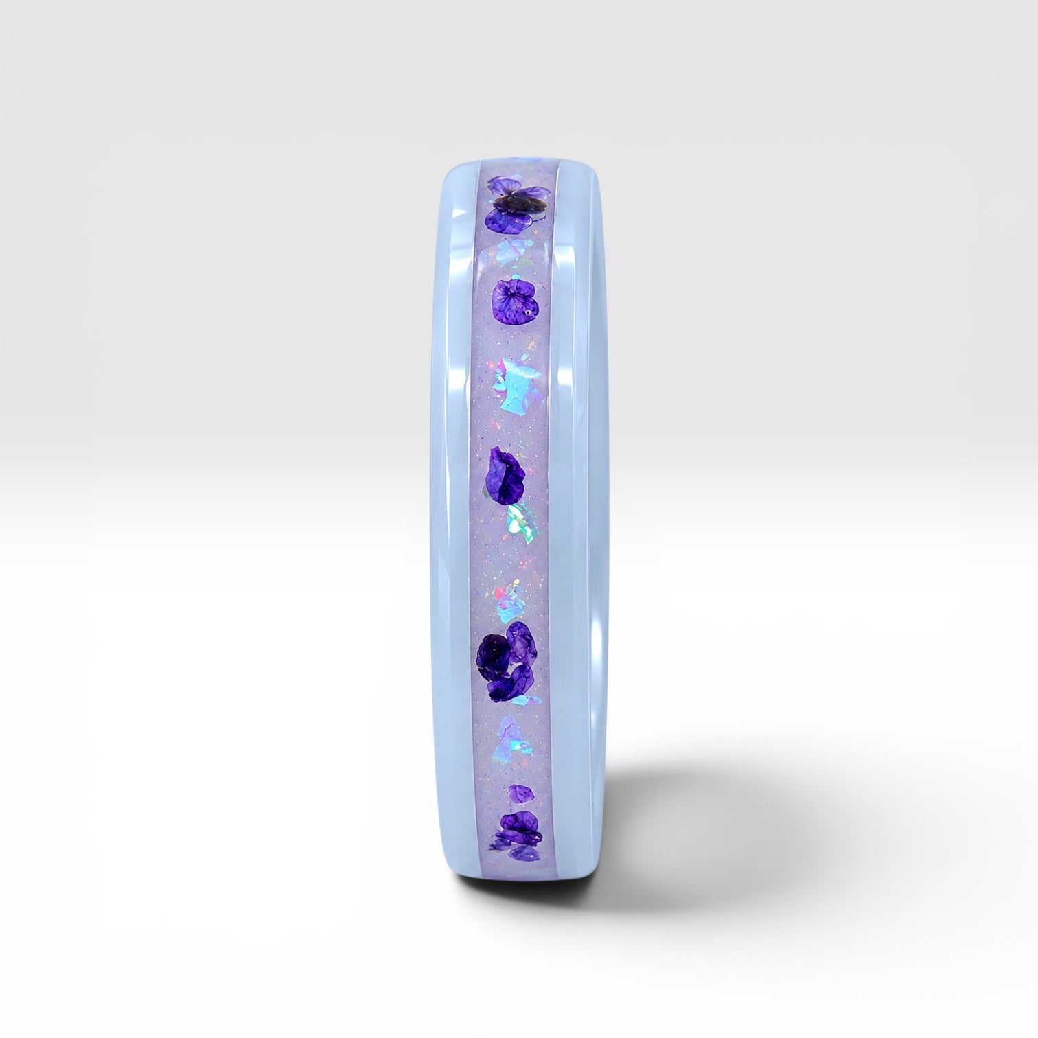 Forget Me Not white ceramic ring with real pressed flowers over a glow-in-the-dark background, handcrafted memorial jewelry