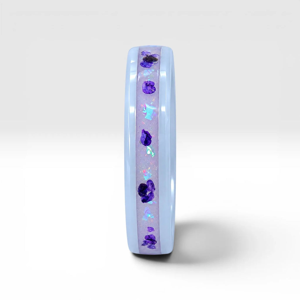 Forget Me Not white ceramic ring with real pressed flowers over a glow-in-the-dark background, handcrafted memorial jewelry