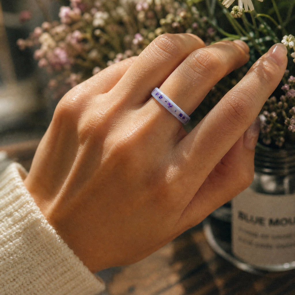 Forget Me Not white ceramic ring with real pressed flowers over a glow-in-the-dark background, handcrafted memorial jewelry