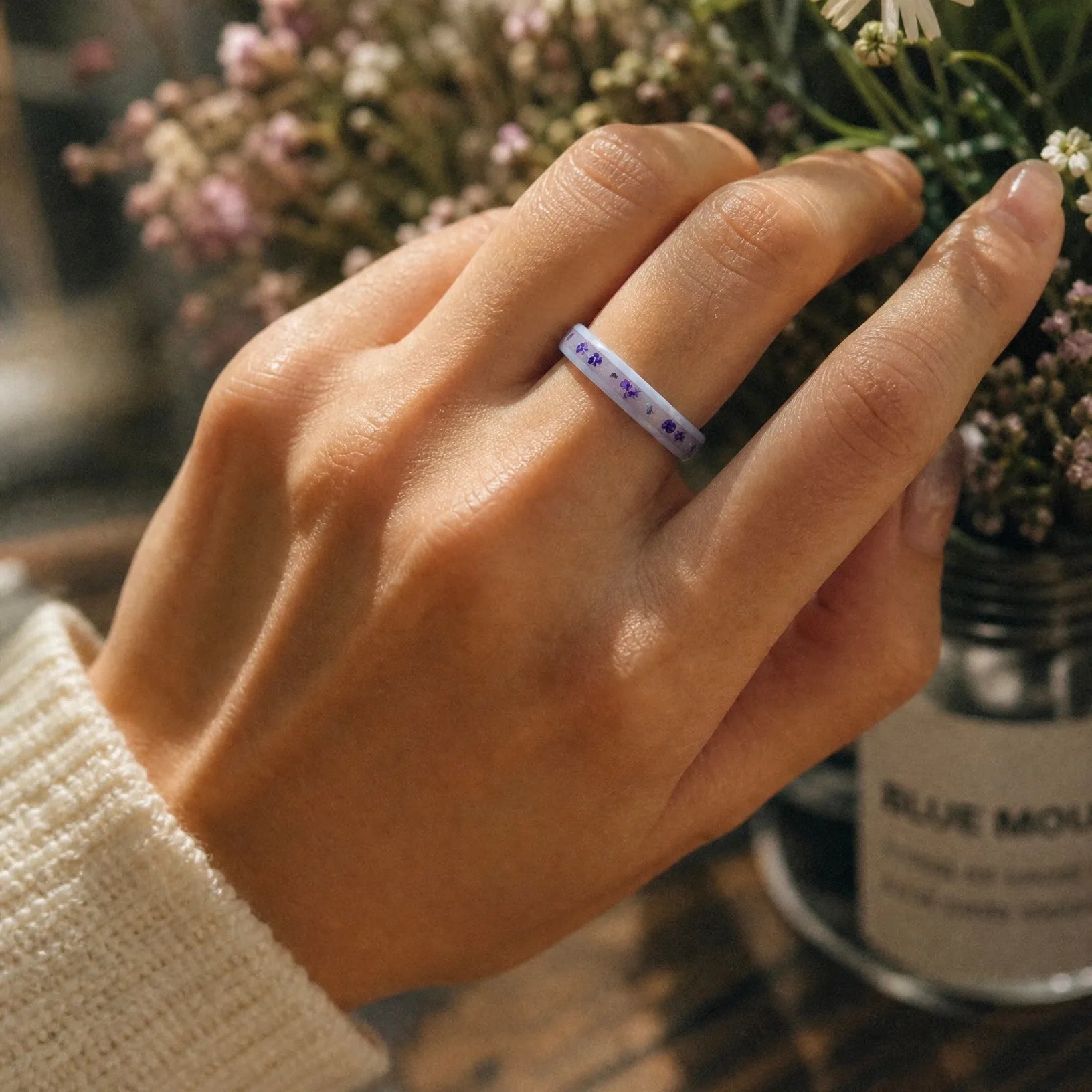 Forget Me Not white ceramic ring with real pressed flowers over a glow-in-the-dark background, handcrafted memorial jewelry