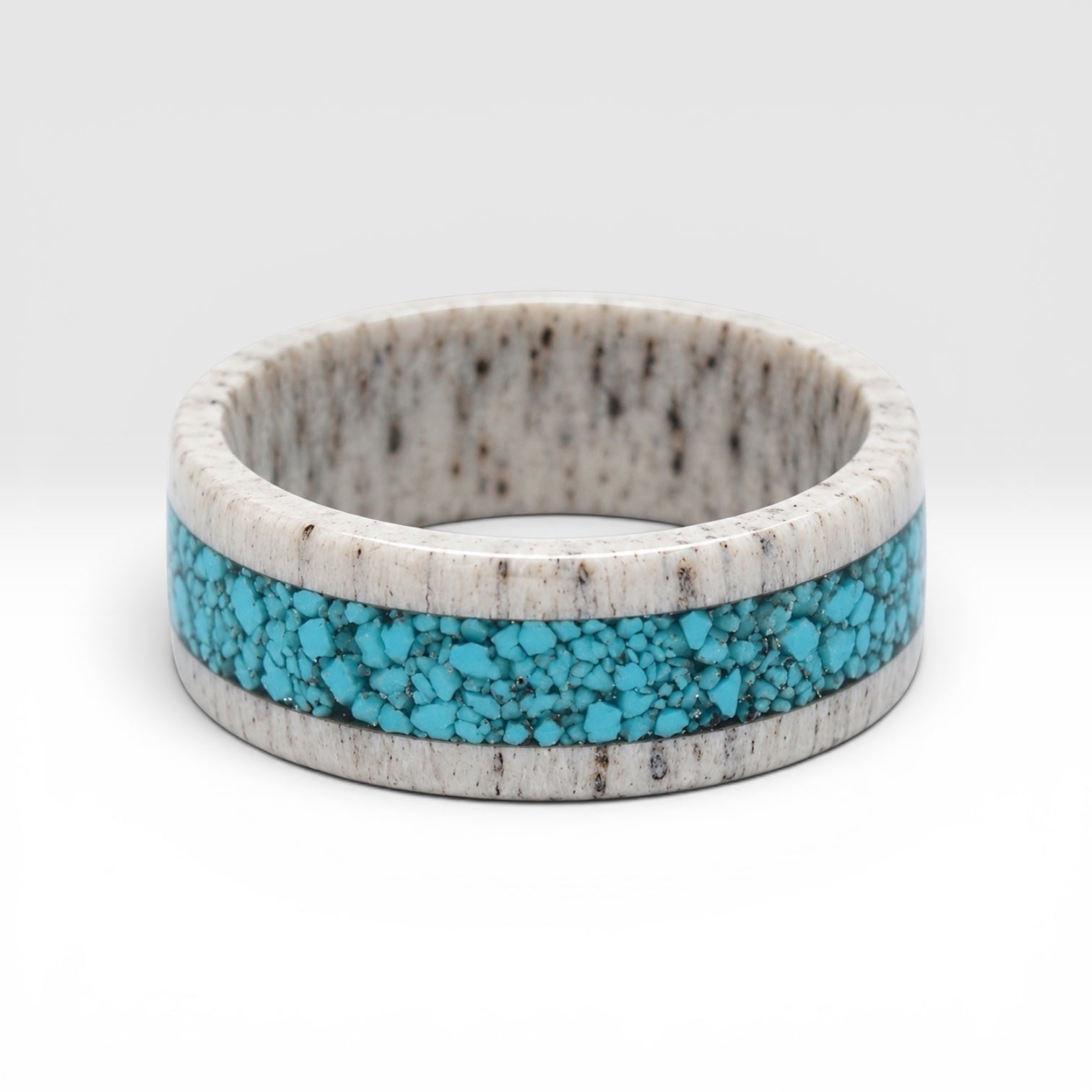 Close-up of deer antler ring with crushed turquoise inlay showing natural texture and stone detail