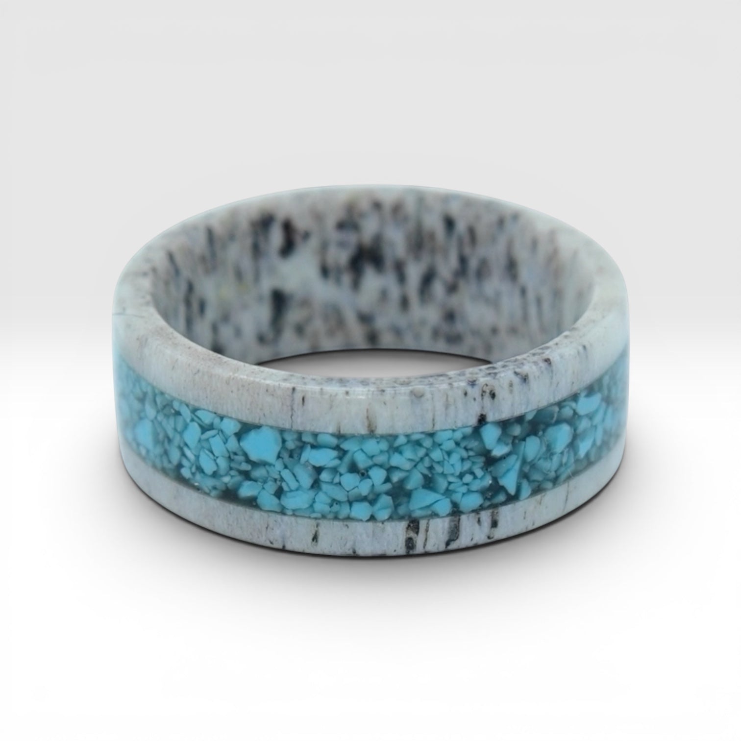 Close-up of deer antler ring with crushed turquoise inlay showing natural texture and stone detail
