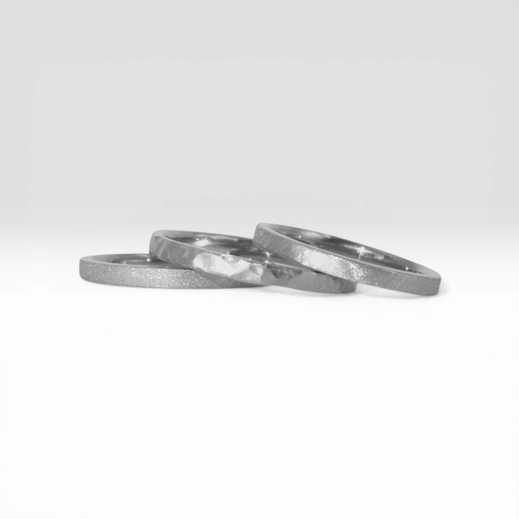 Órbita stack set — three sterling silver stacking rings with different handcrafted finishes laid out for mix and match styling