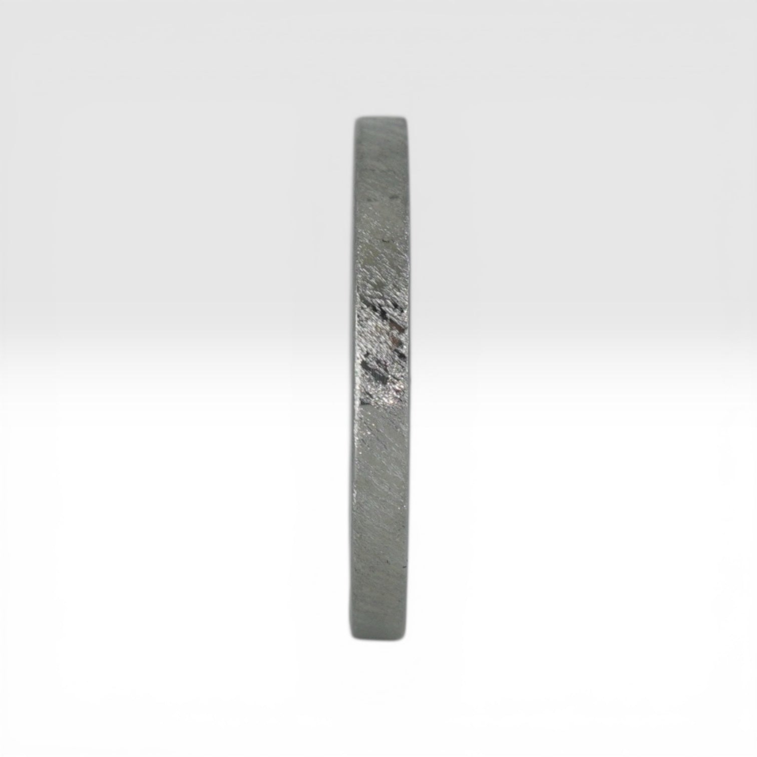 Top view of Órbita Corte diagonal texture titanium stacking ring showing unique angled finish and slim 2mm profile