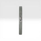 Top view of Órbita Corte diagonal texture titanium stacking ring showing unique angled finish and slim 2mm profile