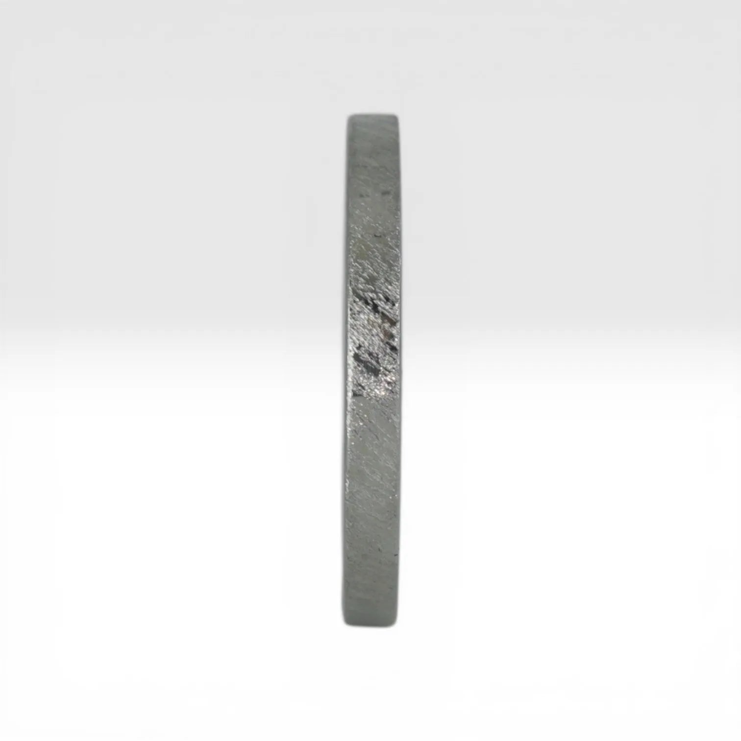 Top view of Órbita Corte diagonal texture titanium stacking ring showing unique angled finish and slim 2mm profile