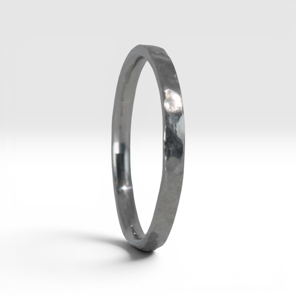 Side view of Órbita Roca hammered stacking ring showing raw textured surface and slim 2mm profile