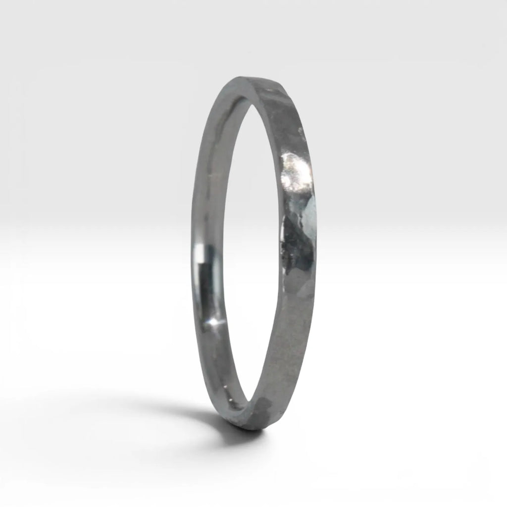 Side view of Órbita Roca hammered stacking ring showing raw textured surface and slim 2mm profile