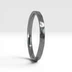 Side view of Órbita Roca hammered stacking ring showing raw textured surface and slim 2mm profile
