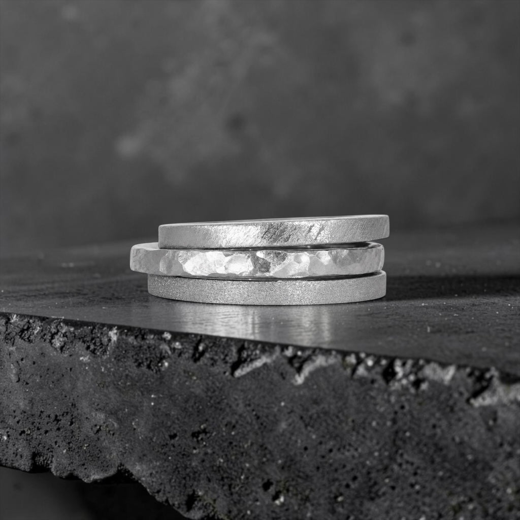Órbita collection — three 2mm  stackable rings stacked together showing hammered, frosted, and diagonal textures, handcrafted in Utah