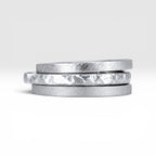 Órbita collection — three 2mm sterling silver stackable rings stacked together showing hammered, frosted, and diagonal textures, handcrafted in Utah