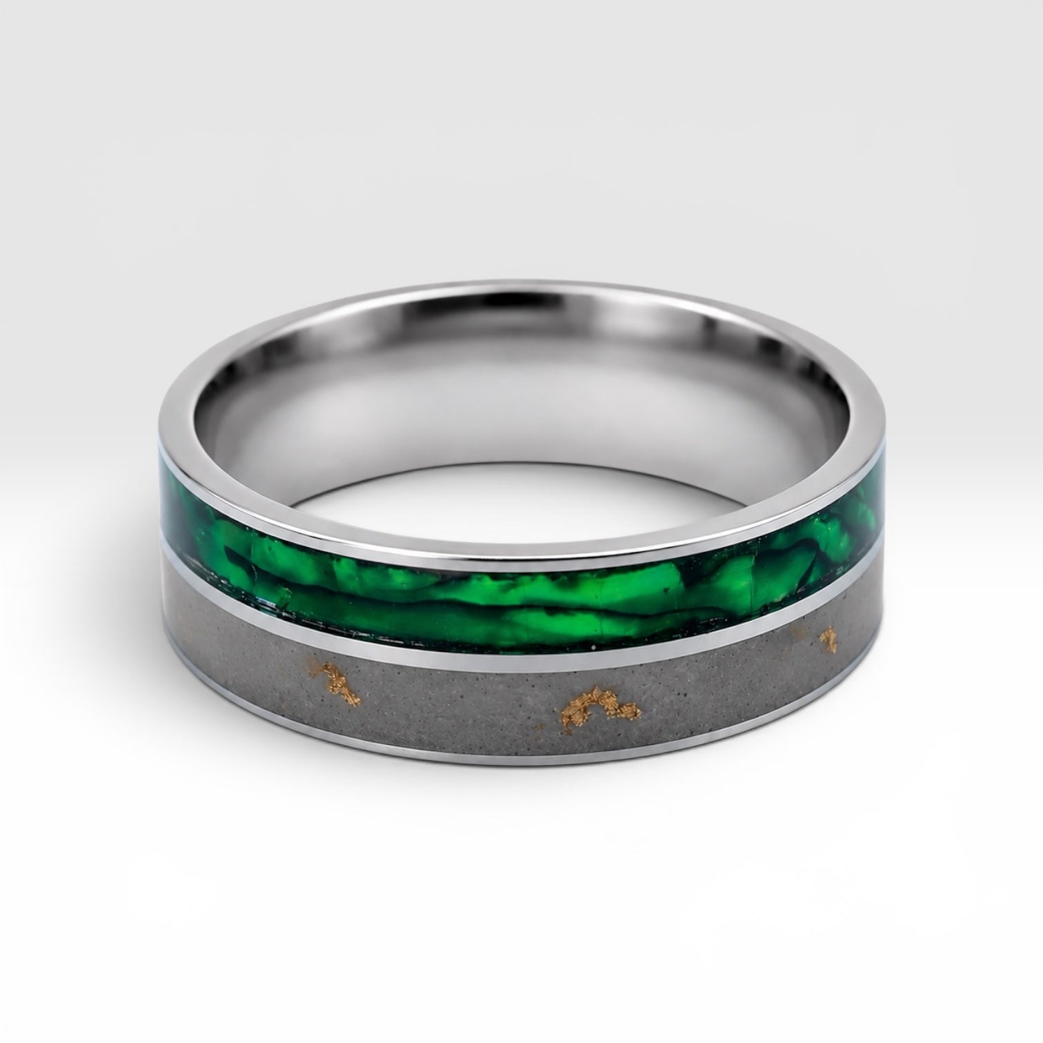 Close-up of titanium ring with paua shell inlay showing iridescent blue, green, and purple tones