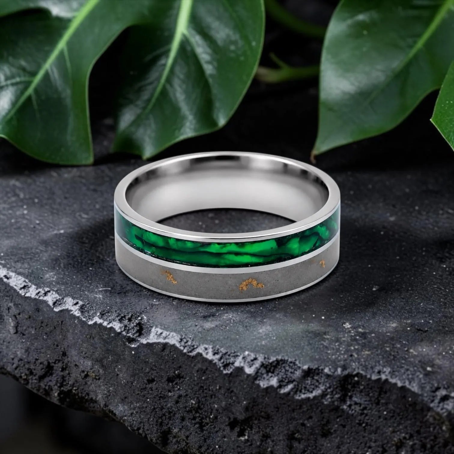 Close-up of titanium ring with paua shell inlay showing iridescent blue, green, and purple tones