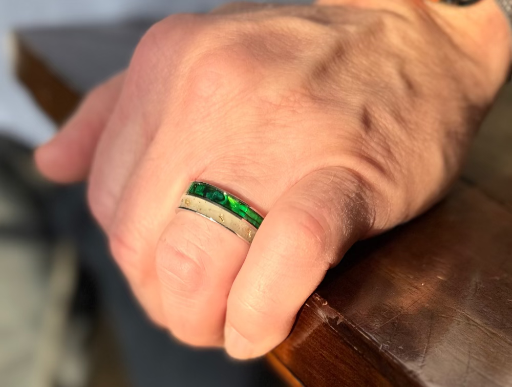 Titanium paua shell ring worn on hand with vibrant iridescent finish