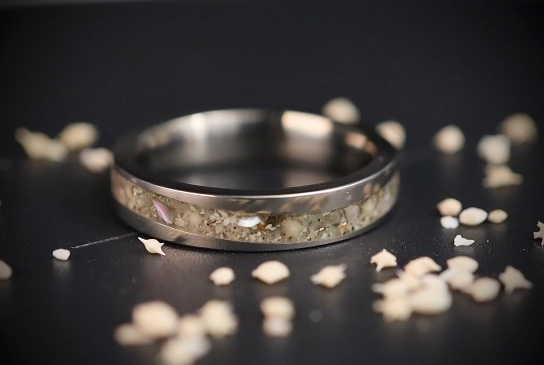 Stellatide titanium ring featuring Bermuda beach sand, Okinawa star sand, and mother of pearl inlay handcrafted by Venus Rings.