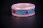 Skyblossom pink ceramic ring featuring preserved blue flower petals, pink pressed flowers, and iridescent accents in a handcrafted floral inlay.