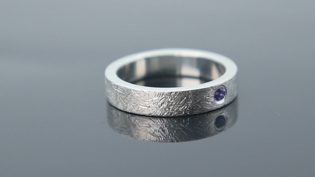 Silver ring with meteorite inspired texture and flush set blue topaz adding contrast