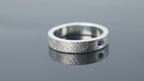 Silver ring with meteorite inspired texture and flush set blue topaz adding contrast