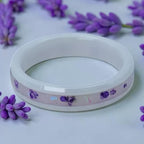 Glow-in-the-dark ceramic ring with real pressed flowers, luminous background at night