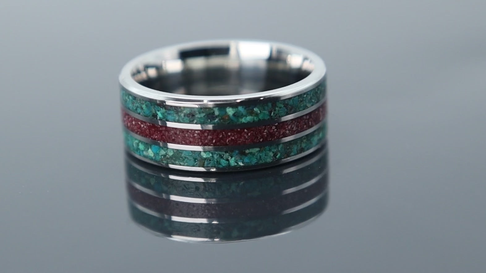 Tungsten ring with textured inlay of chrysocolla and cinnabar forming a rich, layered surface