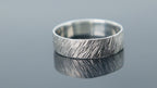 Silver ring with rugged meteorite finish creating a raw and organic surface pattern