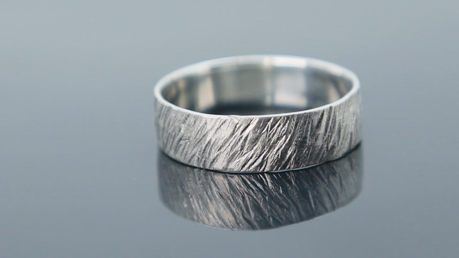 Silver ring with rugged meteorite finish creating a raw and organic surface pattern