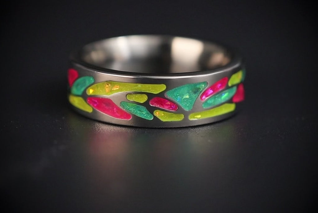 Arcadia titanium ring featuring a colorful abstract inlay with multi-color glow-in-the-dark elements inspired by retro arcade aesthetics.