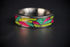 Arcadia titanium ring featuring a colorful abstract inlay with multi-color glow-in-the-dark elements inspired by retro arcade aesthetics.